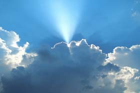 Shaft of light emerging from a cloud and spreading across the bright blue sky like the enlightenment of knowledge disseminated.